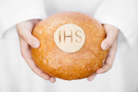 First Holy Communion concept - close up on bread in child's handsの写真素材