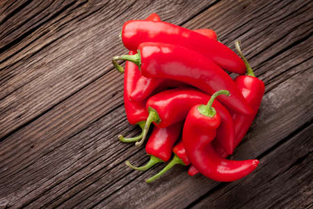 Group of fresh red hot chilli peppers on an old vintage wooden tableの写真素材