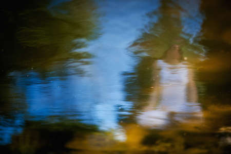 Outdoor yoga session in beautiful garden with a lake - beautiful woman meditating