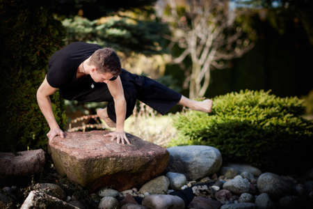Outdoor yoga session in beautiful garden - young man exercising