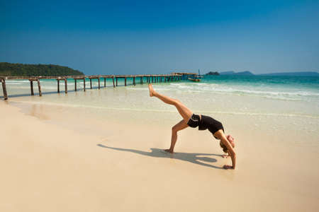 Summer yoga session on a beach - tropical Koh Rong island, Cambodia. Chakra-asana, wheel poseの写真素材