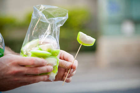 Fresh pieces of green guava in hand. Traditional thai fruit dessert.の写真素材