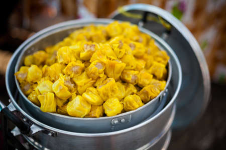 Fresh made squid barbeque skewer in hand. Traditional thai cuisine.の写真素材