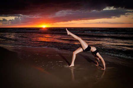 Summer yoga session on a beautiful golden beach - polish Grzybowo village, near to Kolobrzeg. Chakra-asana, wheel poseの写真素材