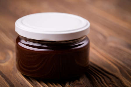 Homemade DIY natural  nutella - chocolate jam made of plums, cacao powder and vanilla. Healthy marmalade in glass jar on a wooden tableの写真素材