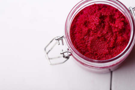 Homemade DIY natural vegan very healthy beetroot paste in a glass jar on a wooden table