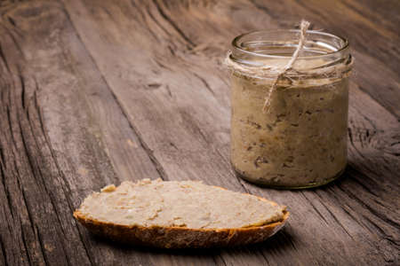 Homemade DIY natural vegan very healthy green lentil paste with rye bread and in a glass jar on a wooden tableの写真素材