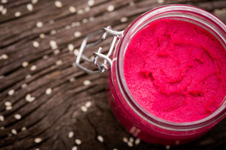 Homemade DIY natural vegan very healthy pink hummus of chickpeas and beetroot in a glass jar on a...