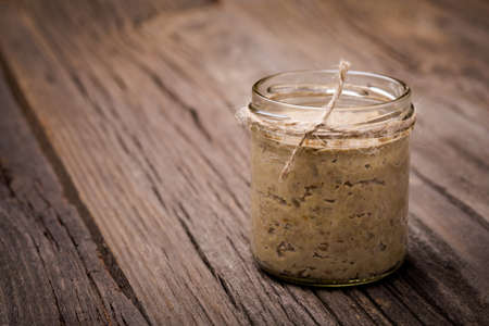 Homemade DIY natural vegan very healthy green lentil paste in a glass jar on a wooden tableの写真素材