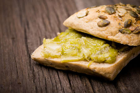 Homemade DIY natural vegan very healthy leek paste with breadroll and in a glass jar on a wooden tableの写真素材