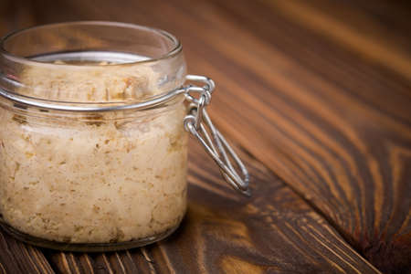Homemade DIY natural vegan very healthy sunflower seeds paste in a glass jar on a wooden table