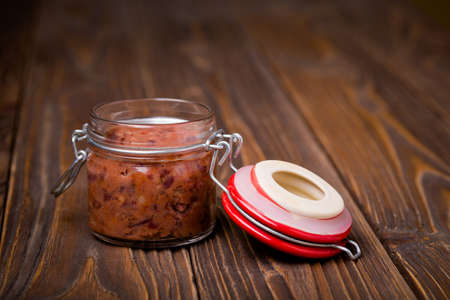 Homemade DIY natural vegan very healthy red bean paste in a glass jar on a wooden table with breadの写真素材