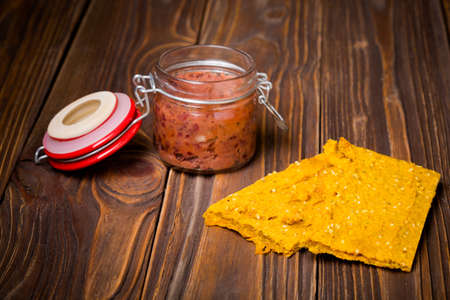 Homemade DIY natural vegan very healthy red bean paste in a glass jar with glutenfree millet gruel flatbread on a wooden table with breadの写真素材