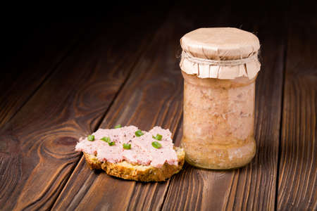 Homemade DIY natural healthy sausage in a jar and with fresh bread on a wooden tableの写真素材