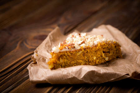 Homemade DIY natural pumpkin cake made with nuts and white chocolate on a wooden tableの写真素材