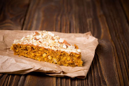 Homemade DIY natural pumpkin cake made with nuts and white chocolate on a wooden table