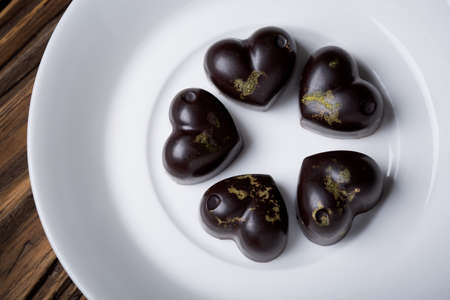 Homemade DIY natural vegan healthy heart-shaped  chocolate pralines with matcha green tea made of...