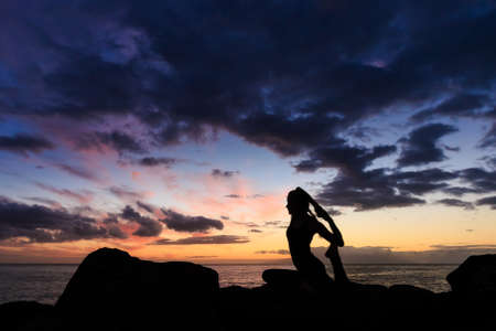 Summer sunset yoga session on beautiful Playa Fanabe beach - tropical Tenerife island, Canary in Spain. Eka Pada Rajakapotasana - legged king pigeon poseの写真素材