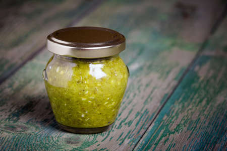 Homemade DIY natural extra hot kenya chilli sauce in a glass jar on wooden tableの写真素材