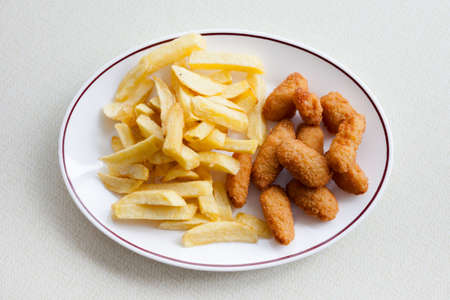 Traditional english meal - deep fried seafood, scampi with chips served in local restaurant in Hastings, England.の写真素材