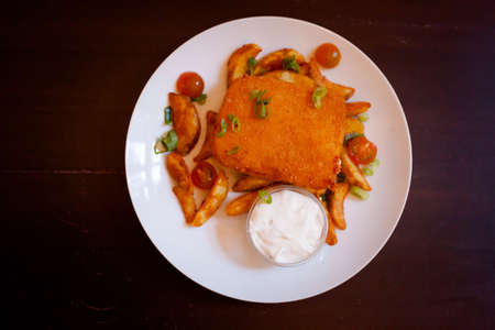 Delicious and the most famous czech battered deep fried cheese, potato wedges and tartar sauce served in local restaurant in Stary Jicin. Moravian food specialities.の写真素材