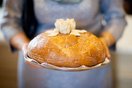 Wedding bread with salt detail on hands - traditional polish inviting to Bride and Groom.の写真素材