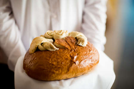 Wedding bread with salt detail on hands- traditional polish inviting to Bride and Groom.の写真素材