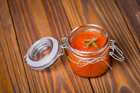Homemade DIY natural organic pumpkin ketchup in a glass jar on a beautiful wooden tableの写真素材