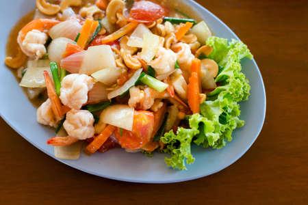 Fresh fried prawns with carrot, onion, tomatoes and cashew nuts. Traditional thai cuisine.の写真素材
