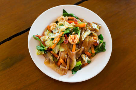 Fresh fried wide rice noodle with cabbage, carrot, chilli and seafood. Traditional thai cuisine.の写真素材