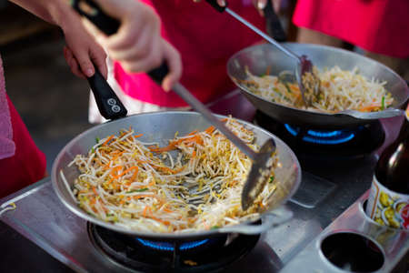 Cooking spring rolls stuffing in wok frying pan. Picture of traditional thai cuisine made of fresh ingredients taken during cooking class in Chiang Mai.の写真素材