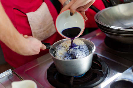 Preparing blue sticky rice coloured by butterfly pea tea. Picture of traditional thai cuisine made of fresh ingredients taken during cooking class in Chiang Mai.の写真素材