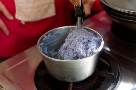 Preparing blue sticky rice coloured by butterfly pea tea. Picture of traditional thai cuisine made of fresh ingredients taken during cooking class in Chiang Mai.の写真素材