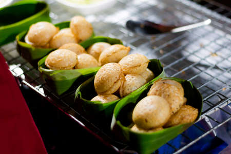 Fresh prepared asian fried coconut cakes served in banana leaf. Traditional thai cuisine made of fresh ingredients.の写真素材