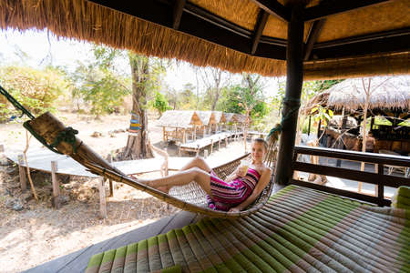 Young caucasian girl tourist relaxing close to big Li Phi waterfall in Laos - Tat Somphamit, don khone, si phan don on four thousand islands in Laos. Vacation in south east Asia.のeditorial素材