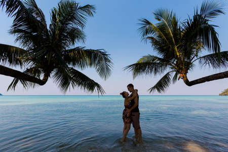 Summer landscape on tropical Koh Kood island in Thailand. Beautiful young caucasian couple on panorama of white sand beach with coconut palms taken on Klong Chao.のeditorial素材