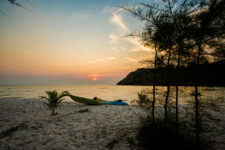 Summer landscape on tropical koh Kood island in Thailand. Panorama of white sand beach with coconut palms during colorful sunset taken on Klong Chao.の写真素材