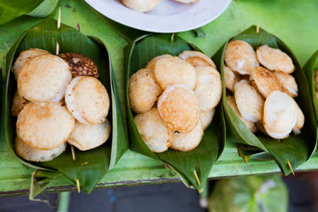 Fresh prepared asian fried coconut cakes served in banana leaf. Traditional thai cuisine made of fresh ingredients.の写真素材