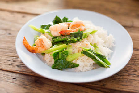 Thai fried kale with shrimps served on steamed rice. Traditional south east asian cuisine.の写真素材
