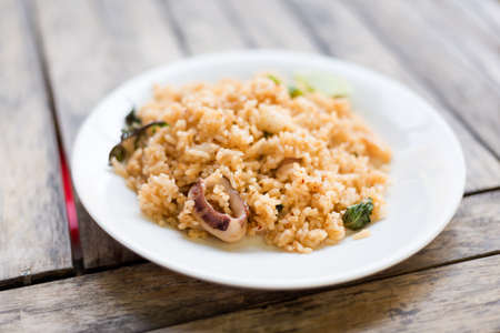 Fresh fried yasmin rice with squid and holy basil . Traditional thai seafood cuisine.の写真素材