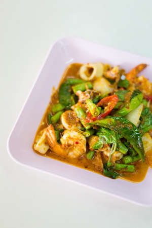 Mix of prawns and squid seafood fried with onion, chilli and long green in red hot curry sauce. Traditional south east asian cuisine.の写真素材