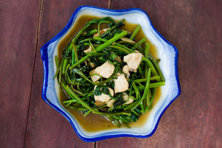 Lao fried morning glory with chicken, bird eye chilli and garlic. Traditional south east asian...