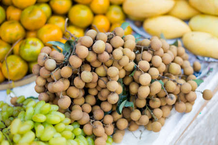 Bunch of fresh longan fruits on local market. Popular lao sweet fruits.の写真素材