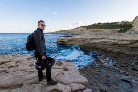 Young tourist on St Peter's Pool beach and lagoon on Malta island. Beautiful landscape in south Europe.の写真素材