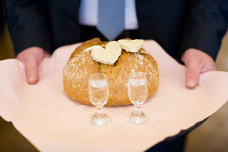 Wedding bread with salt detail on hands- traditional polish inviting to Bride and Groom.の写真素材
