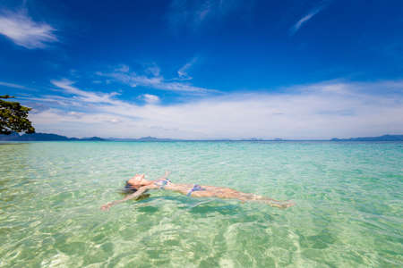 Summer landscape with young caucasian woman  tourist relaxing in sea on tropical koh Kradan island  in Thailand. Holiday photos taken in paradise scene.の写真素材