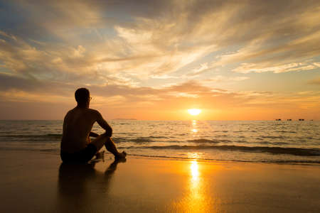 Summer landscape with young caucasian tourist watching golden sunset on tropical koh Kradan island in Thailand. Holiday photos taken in paradise scene.の写真素材