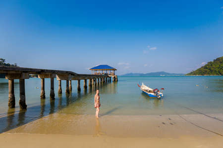Young girl tourist on Teluk Dalam beach on Pangkor island in Malaysia. Beautiful seascape and harbor taken in south east Asia.の写真素材