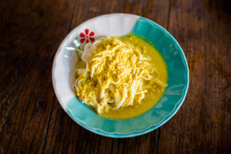Fresh prepared asian spicy yellow peanut satay fish curry Khanom Jeen. Traditional thai breakfast...