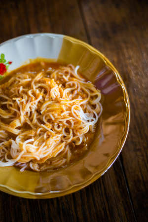Fresh prepared asian spicy yellow fish curry Khanom Jeen. Traditional thai breakfast cuisine made of...
